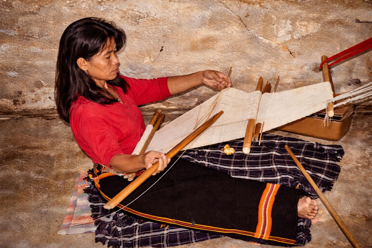 Tribal woman weaving on a traditional handloom